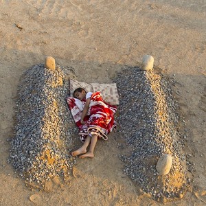 Syryjski chłopciec, śpiący między grobami rodziców? Fotograf zaprzecza